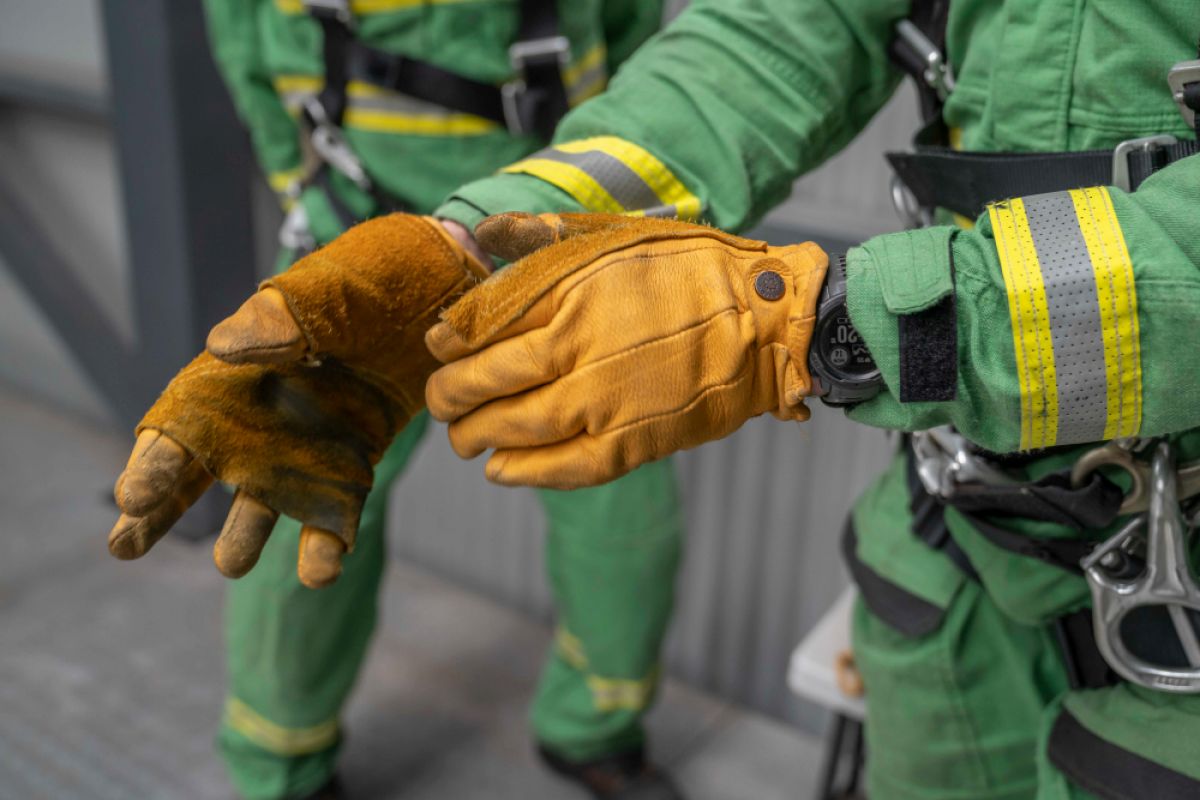 Close-up of person putting on heavy duty yellow gloves