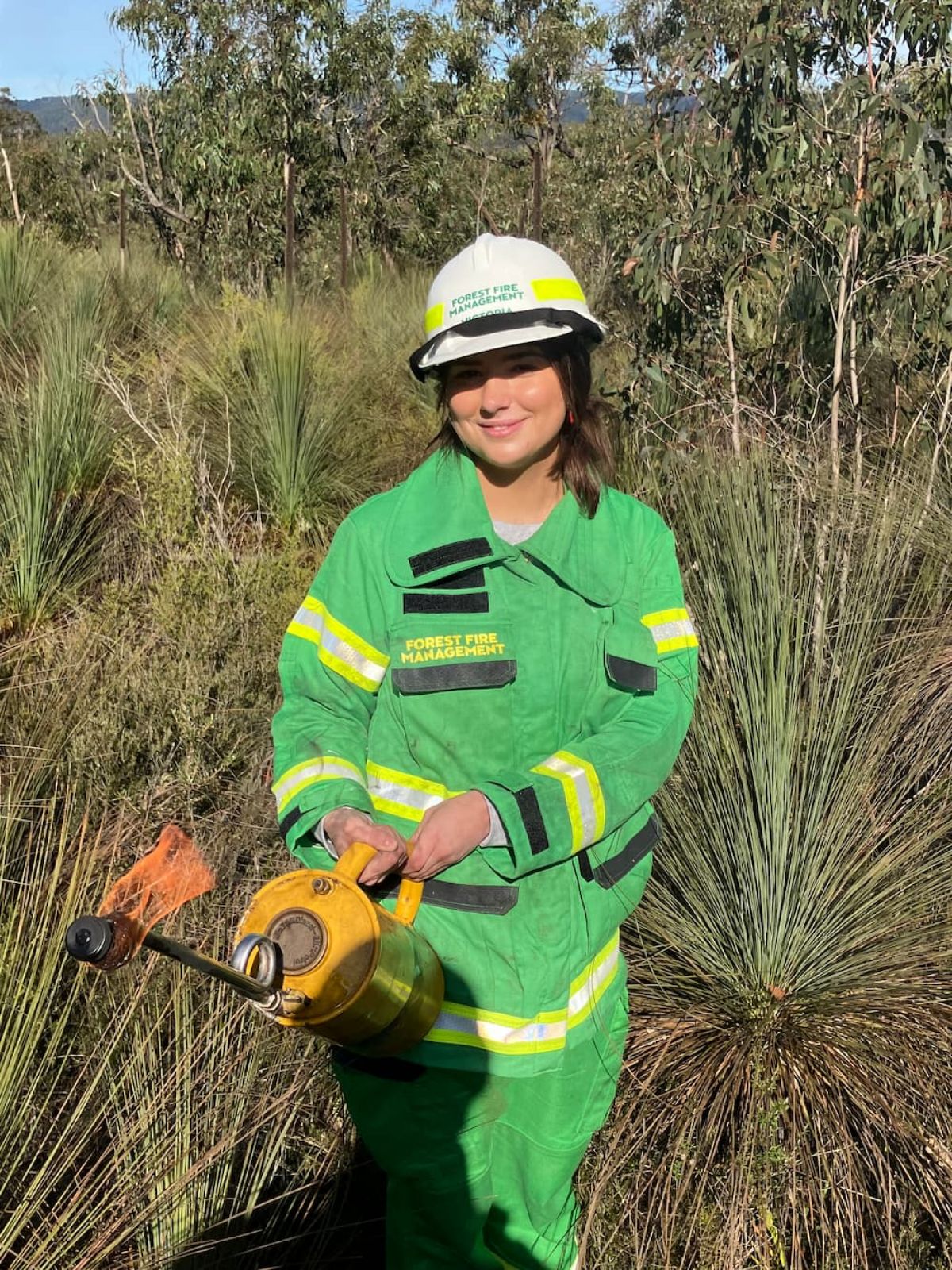 Woman in helmet holding drip torch